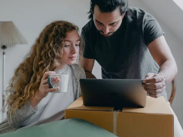 Digital marketing for mortgage lenders; couple looking at a computer with moving boxes in the background