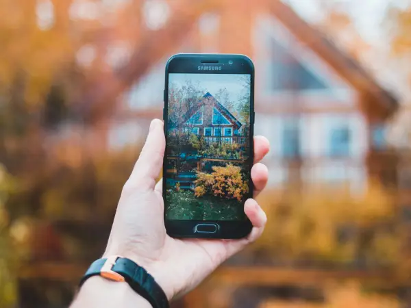 Loan officer content marketing — person taking a picture of a home