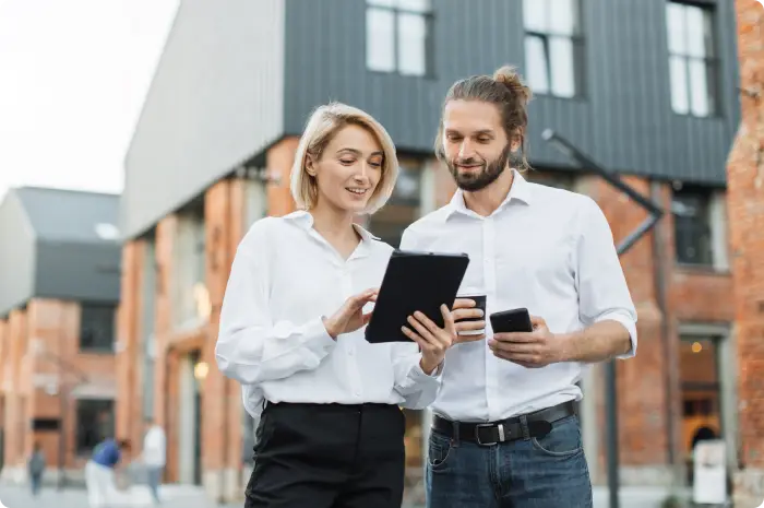 Loan officer and real estate agent in front of a house